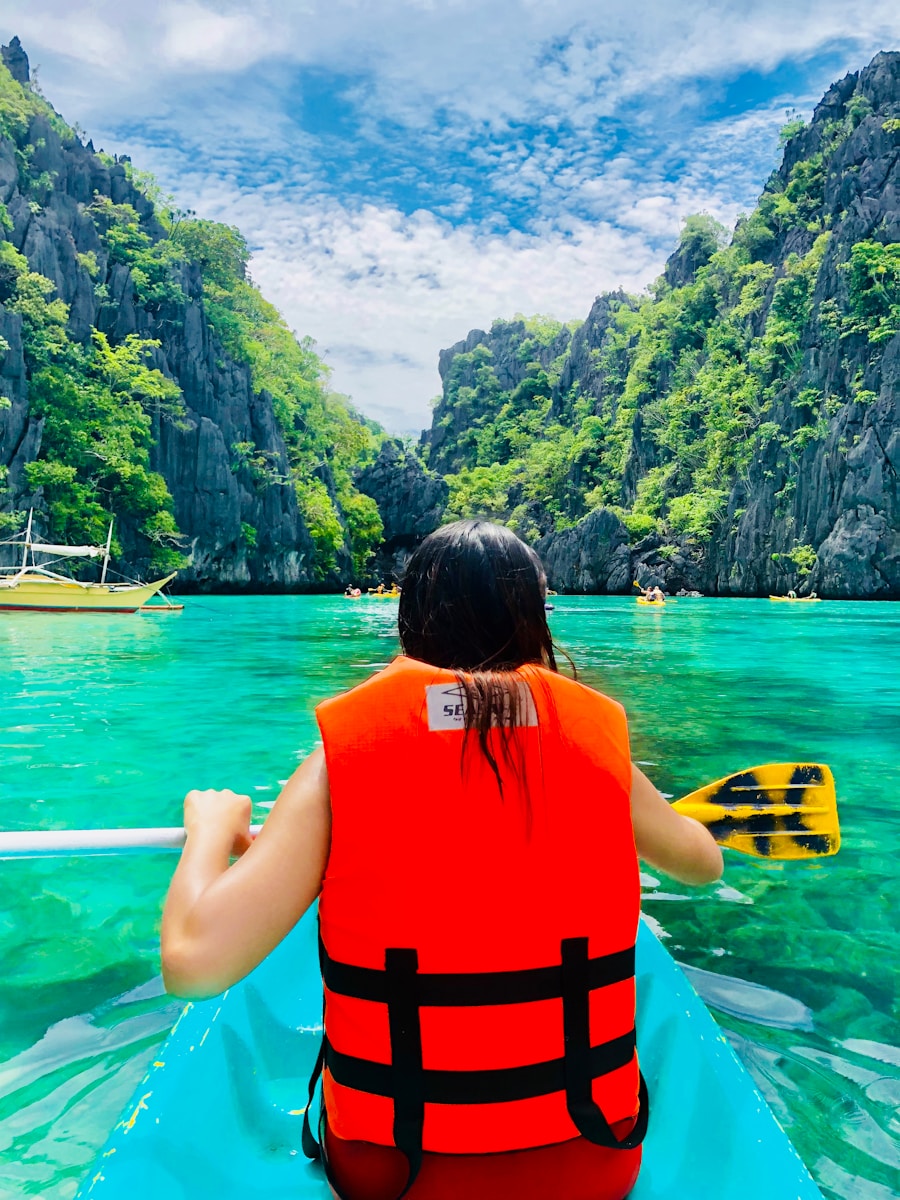 woman in orange and black life vest sitting on yellow boat on blue sea during daytime